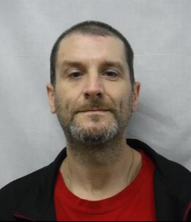 Man with short dark hair and a graying beard.