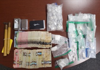 Stacks of currency and baggies of a white powdery substance.