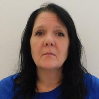 Woman with long black hair and blue shirt.
