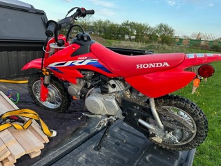 Red dirt bike on a truck bed.