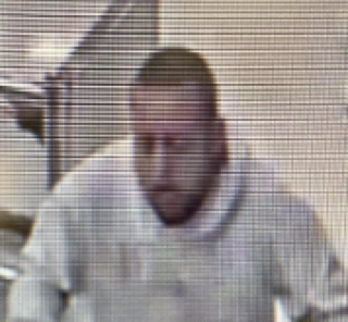 Close-up of a person with a short beard and a light-colored shirt.