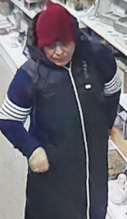 Person wearing a red hat, dark jacket, and blue shirt with white stripes.