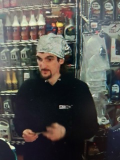 Man wearing a white chef's hat and black uniform.