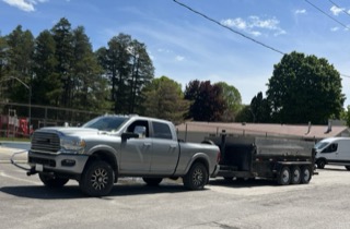 Silver pickup truck towing a trailer.