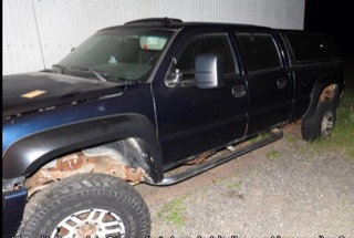 Black pickup truck with lifted suspension and large tires
