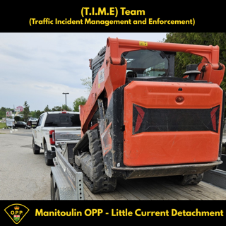 Orange skid steer on a trailer.