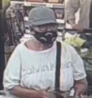Person wearing a face mask and baseball cap