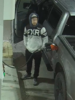 Person filling a gray SUV with gas