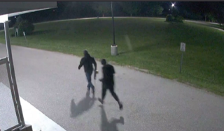 Two people running across a paved area.