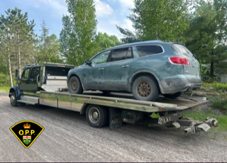 Green SUV on a flatbed tow truck
