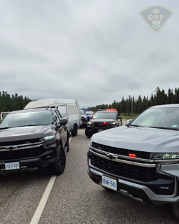 Police vehicles traveling on a highway.