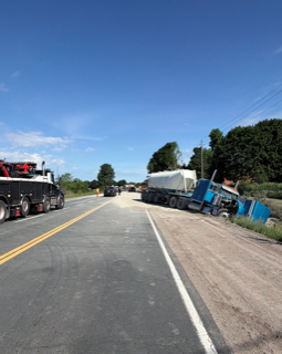 Semi-truck overturned on shoulder of a two-lane road