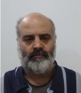 Man with a shaved head and full gray beard