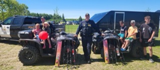 Police officer and two boys posing with an ATV.