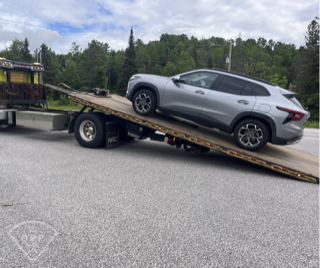 Silver SUV on a car trailer.