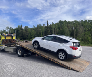 White SUV on a car trailer.