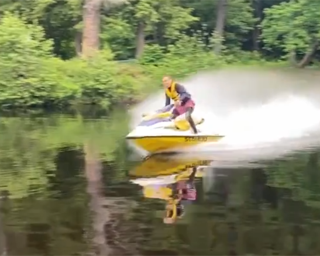 Person waterskiing, spray visible