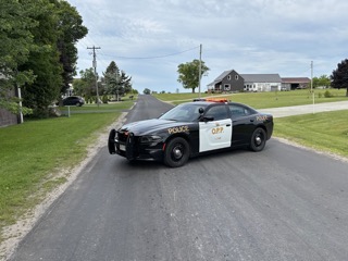 Black police cruiser parked on a residential street.