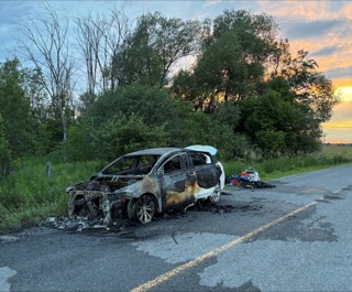 Damaged car on roadside, debris scattered