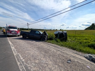 Damaged pickup truck and SUV off a rural road