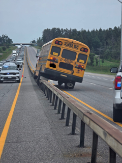 School bus on highway, police car nearby