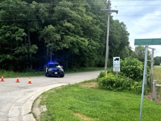 Police car with flashing lights on a roadside.