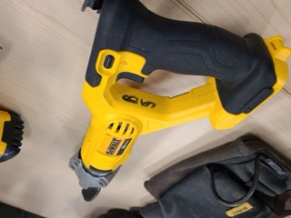Yellow and black cordless saw, black work gloves