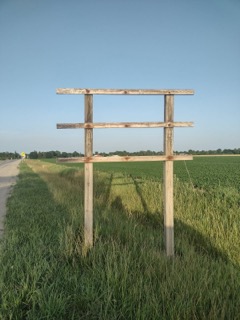 Two weathered wooden posts with crossbeams.