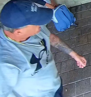 Man wearing a baseball cap and t-shirt holding a baseball glove
