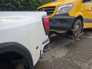 White pickup truck with a trailer hitched.