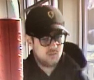 Man wearing a black baseball cap and glasses