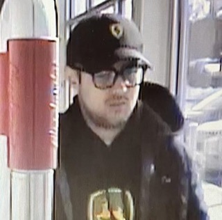 Man wearing a black baseball cap and glasses