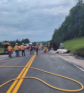Road construction crew working on asphalt road.