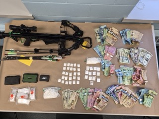 Crossbow and currency on a table.
