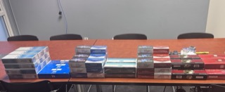 Stacks of cigarette packs and boxes on a red table.
