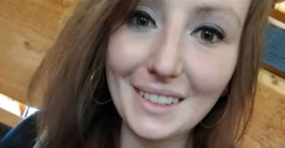 Smiling woman with brown hair and hoop earrings