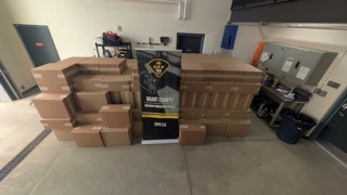 Stacked cardboard boxes, OPP banner, black trash can